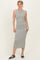 woman wearing a gray and white striped sleeveless midi dress with a fitted silhouette and black sneakers