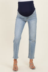 woman wearing light wash maternity jeans with a navy blue over-the-bump waistband and heels