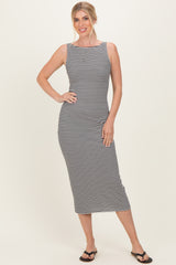 woman wearing a black and white striped midi dress with a fitted silhouette and boat neckline