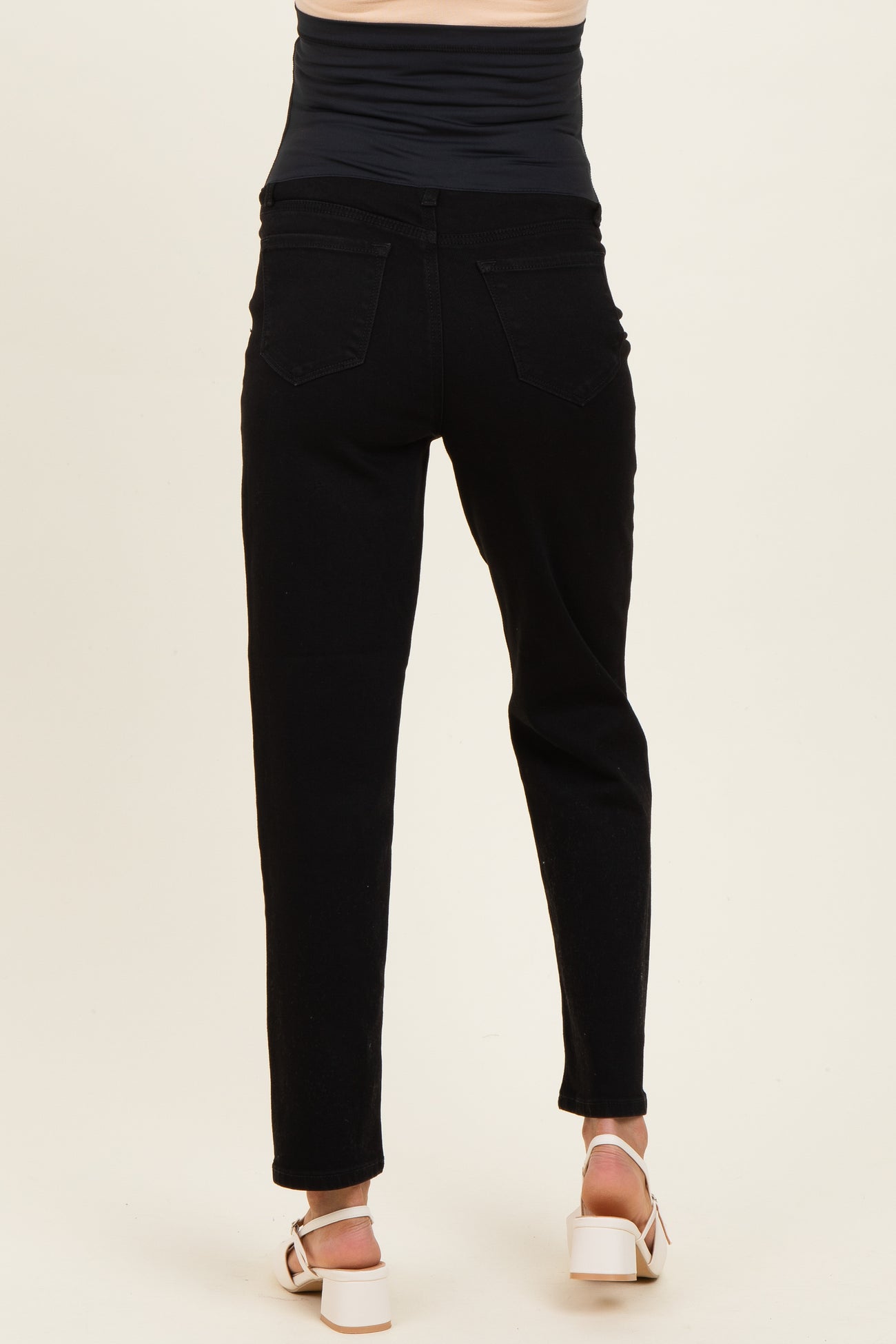 woman wearing black maternity jeans viewed from the back, featuring a stretchy waistband and slim fit