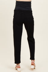 woman wearing black maternity jeans viewed from the back, featuring a stretchy waistband and slim fit