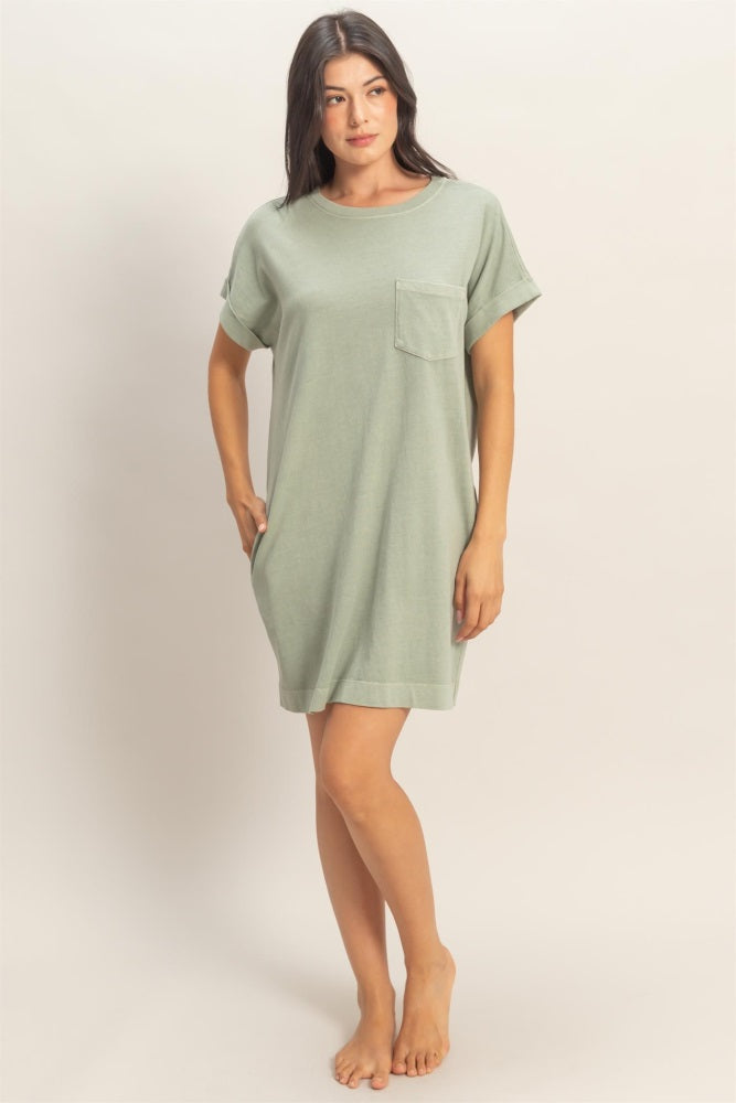 woman wearing a light green oversized t-shirt dress with a chest pocket and rolled sleeves