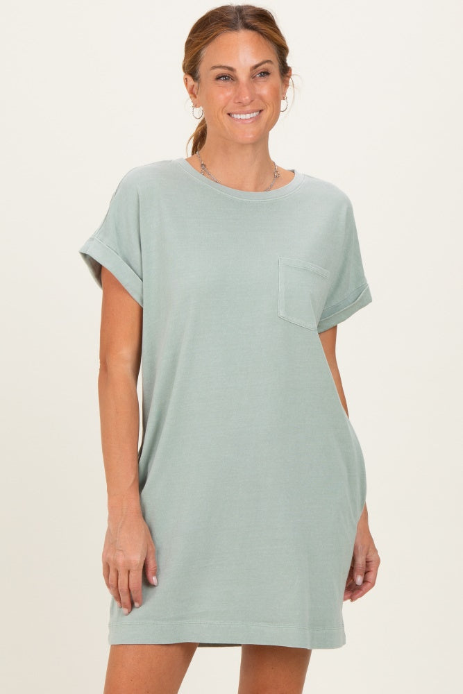 woman wearing a light green oversized t-shirt dress with a pocket and rolled sleeves