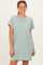 woman wearing a light green oversized t-shirt dress with a pocket and rolled sleeves