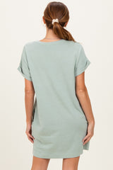 woman wearing a pale green short sleeve loose fit t-shirt dress, showing the back view