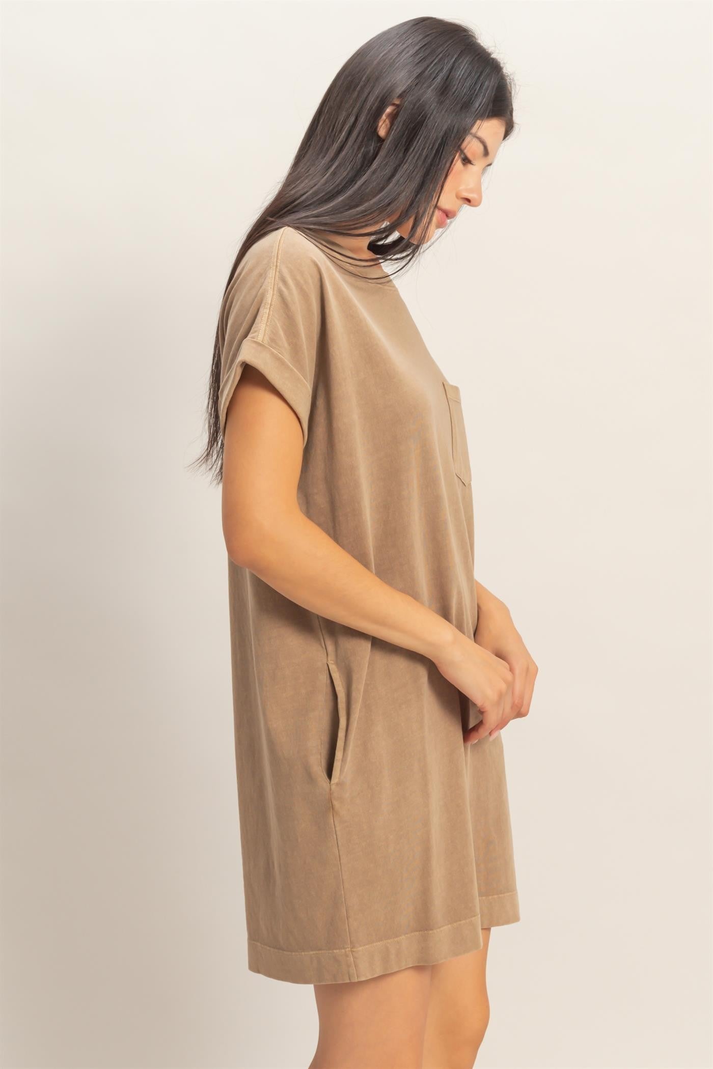 woman wearing a tan short sleeve dress with side pockets and a relaxed fit in a profile view