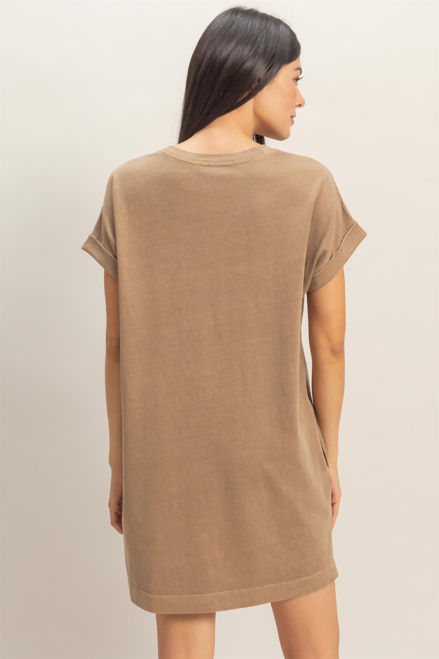 woman wearing a brown oversized t-shirt dress with rolled sleeves, showing the back view