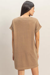 woman wearing a brown oversized t-shirt dress with rolled sleeves, showing the back view