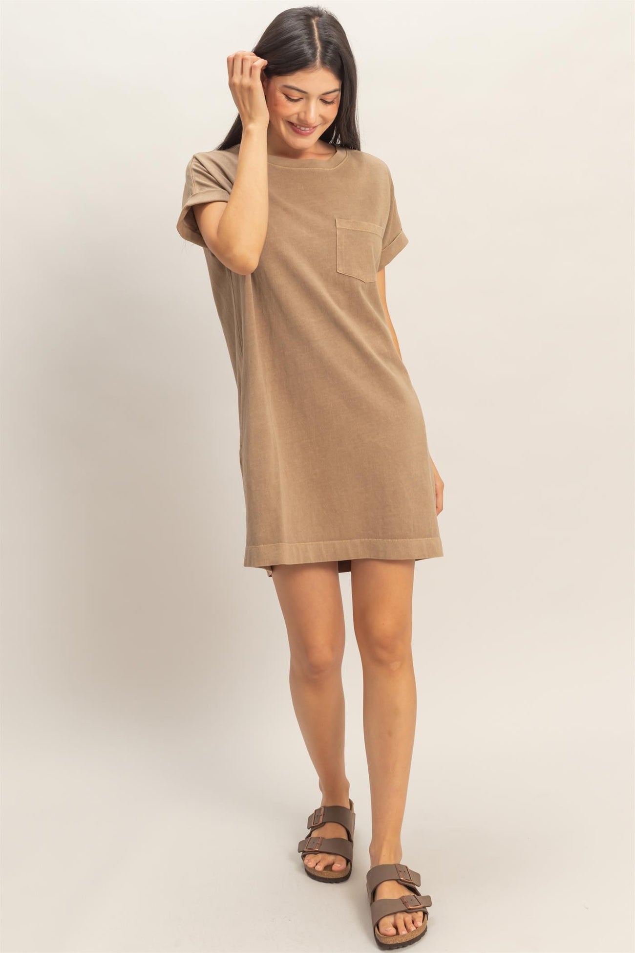 woman wearing a tan short sleeve dress with a pocket and a relaxed fit