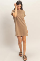 woman wearing a tan short sleeve dress with a pocket and a relaxed fit