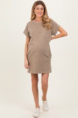 woman wearing a beige short sleeve maternity dress with a pocket and a visible baby bump