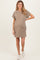woman wearing a beige short sleeve maternity dress with a pocket and a visible baby bump