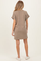 woman wearing a taupe oversized maternity dress, back view, with rolled sleeves and a relaxed fit