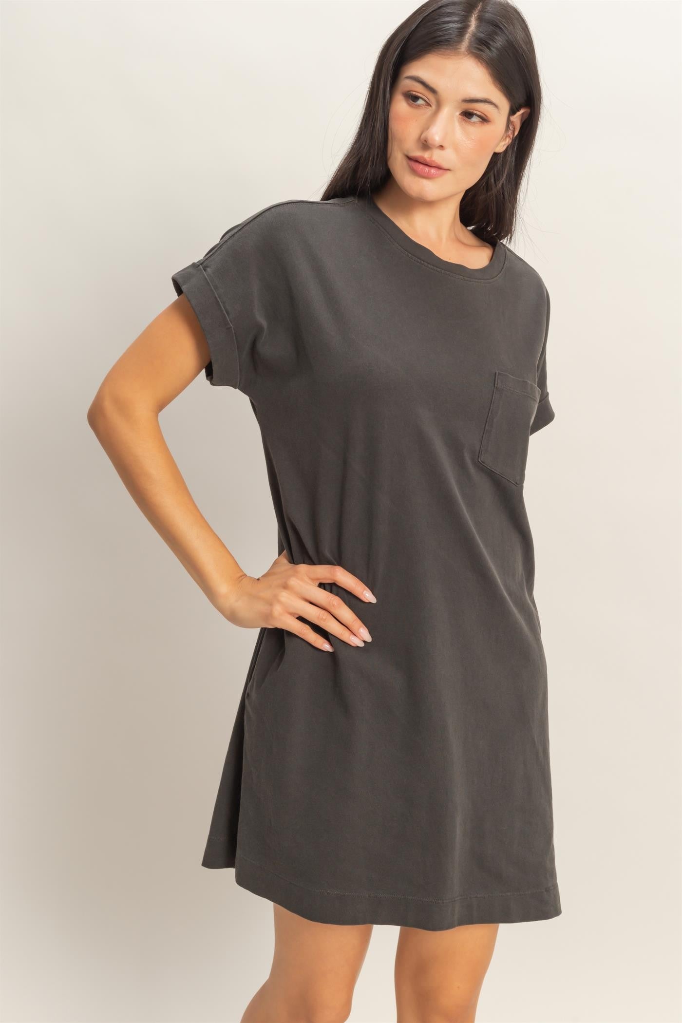 woman wearing a dark gray oversized t-shirt dress with a single chest pocket and rolled short sleeves