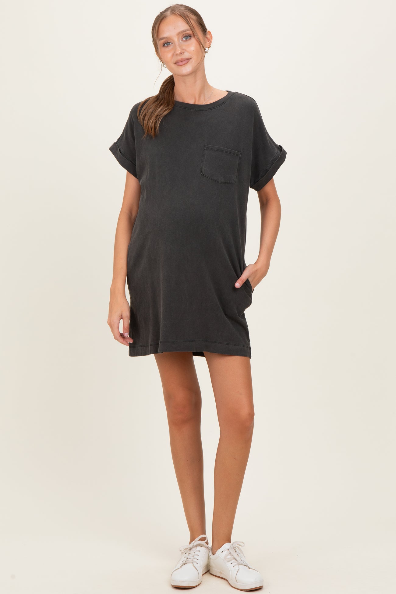 woman wearing a dark grey maternity short sleeve dress with a pocket and a visible baby bump