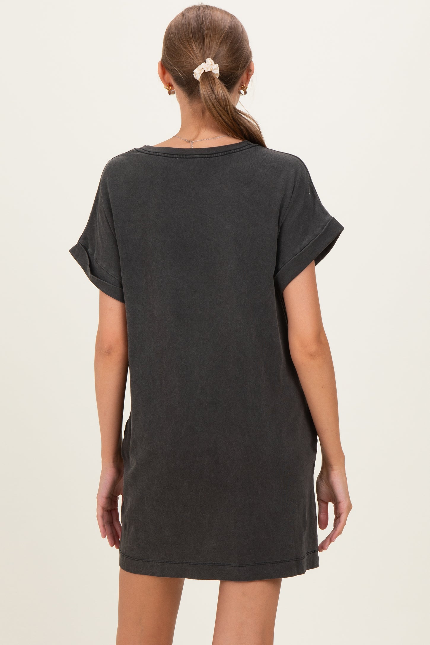 woman wearing a dark gray oversized maternity dress with rolled sleeves