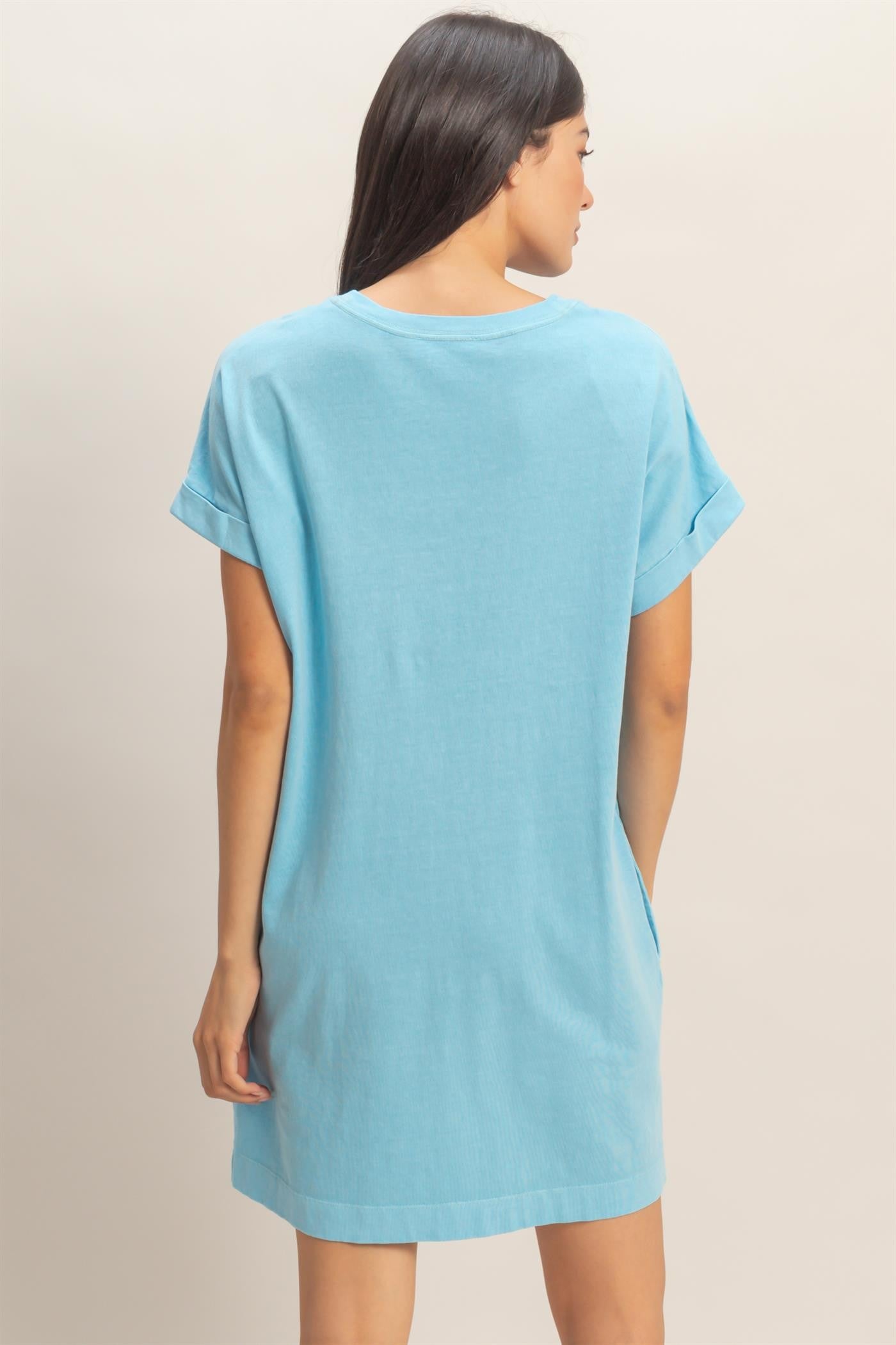 woman wearing a short sleeve light blue tunic dress seen from the back