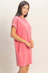 woman wearing a pink short sleeve dress with a front pocket and relaxed fit