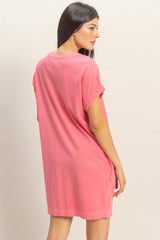 woman wearing a pink oversized t-shirt dress with short sleeves and a relaxed fit