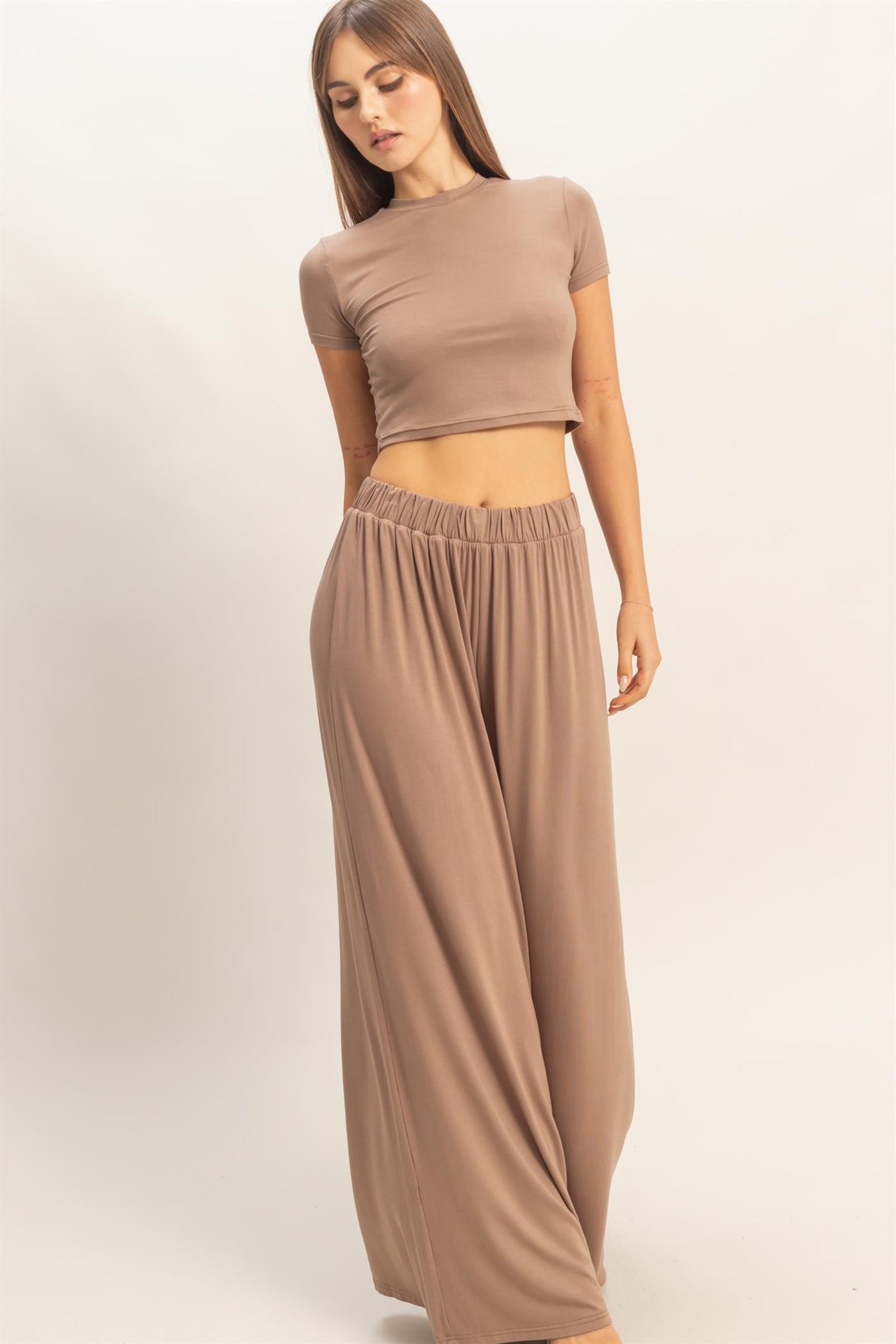 woman wearing a fitted beige crop top and wide-leg beige pants