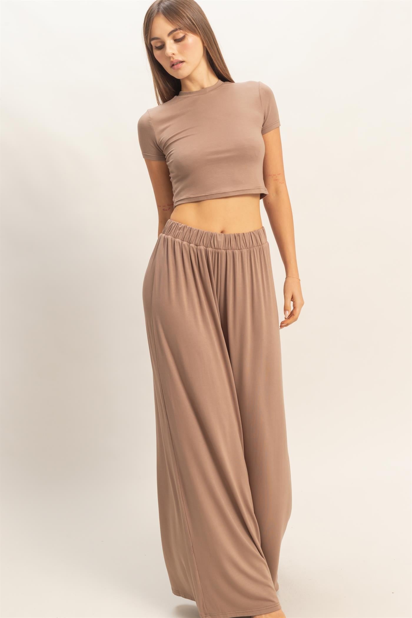 woman wearing a fitted beige crop top and wide-leg beige pants