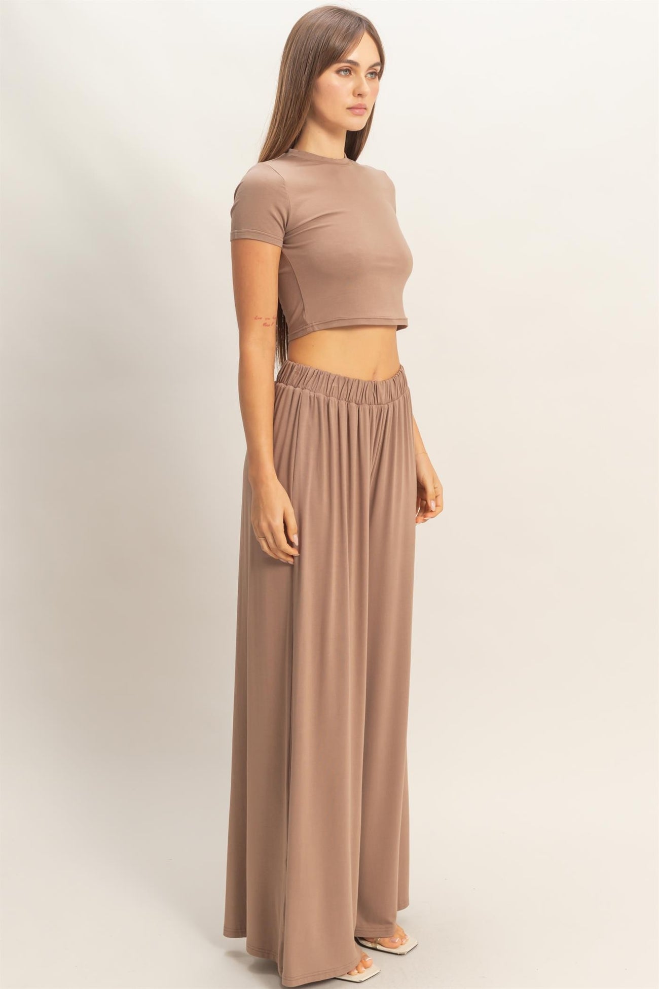 woman wearing a taupe cropped top and matching high-waisted wide-leg pants