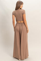 woman wearing a taupe crop top and matching wide-leg pants, showing the back view and waistband details