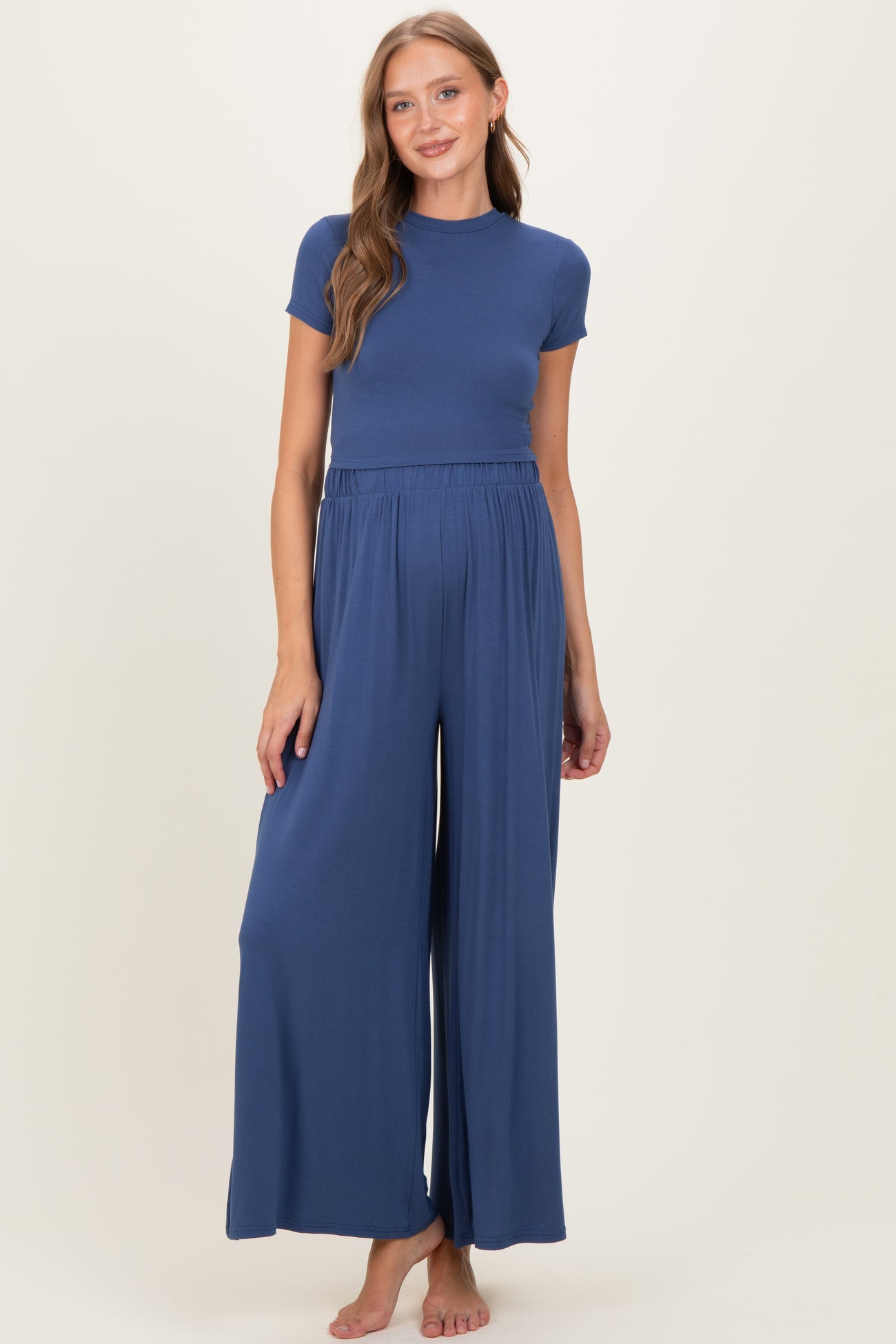 woman wearing a navy blue short sleeve maternity jumpsuit with a fitted top and wide leg pants