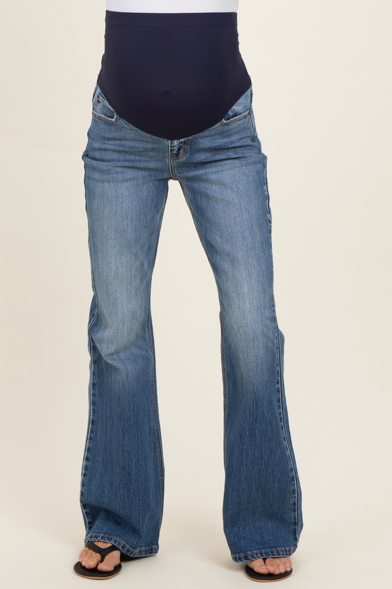 woman wearing blue flared maternity jeans with a supportive belly panel