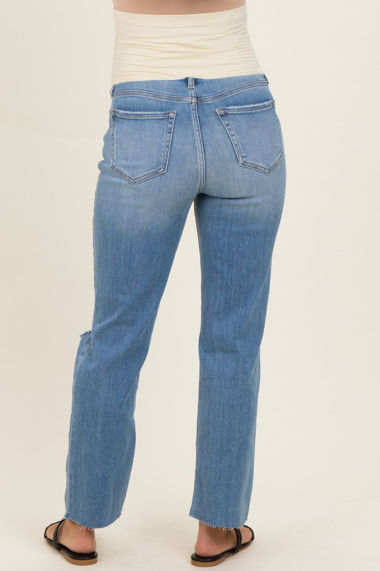 woman wearing light blue maternity jeans with a straight leg cut, showing the back view