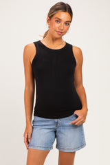 woman wearing a black ribbed maternity tank top and denim shorts, with a visible baby bump