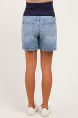 woman wearing light wash maternity shorts with a stretchy navy waistband, viewed from the back