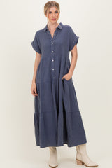 woman wearing a navy blue button-up shirt dress with short sleeves and pockets, styled with cream-colored boots
