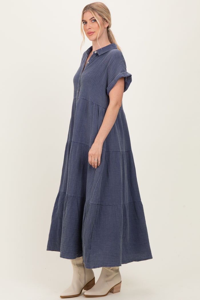 woman wearing a navy blue collared tiered maxi dress with short sleeves and buttons down the front