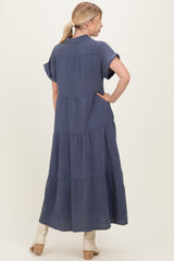 woman wearing a navy blue tiered maxi dress with short sleeves, shown from the back