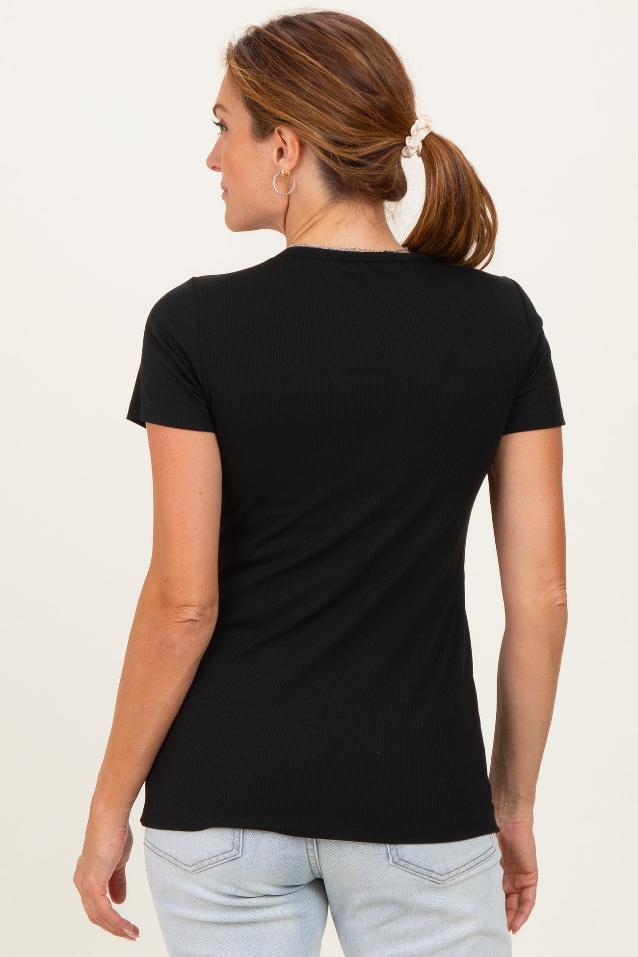 woman wearing a black short sleeve fitted top, seen from the back