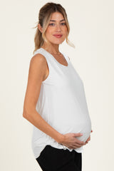 woman wearing a white maternity tank top and holding her baby bump