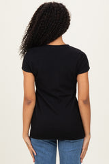 woman wearing a black ribbed short sleeve top, viewed from the back, paired with blue jeans