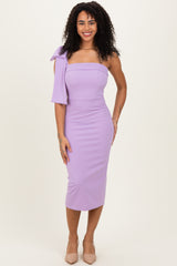 woman wearing a lavender off-the-shoulder midi dress with a stylish bow detail on one sleeve
