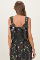 woman wearing a black floral print maternity dress with smocked back and bow details on the straps