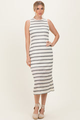 woman wearing a sleeveless white and black striped midi dress with a fitted silhouette and a round neckline