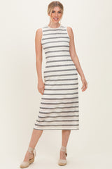 woman wearing a white and navy striped sleeveless midi dress with a fitted silhouette and espadrille wedges