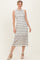 woman wearing a white and navy striped sleeveless midi dress with a fitted silhouette and espadrille wedges