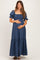 woman wearing a navy blue maternity maxi dress with puff sleeves and a gathered bodice, holding her baby bump
