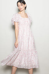 woman wearing a pink floral puff sleeve maxi dress with a square neckline and tiered skirt