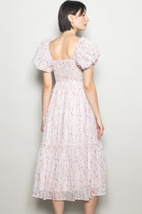 woman wearing a floral midi dress with puff sleeves and a smocked bodice, seen from the back
