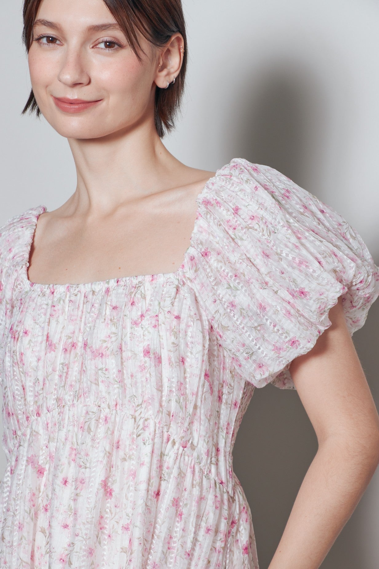 woman wearing a floral puff sleeve dress with a square neckline and gathered bodice