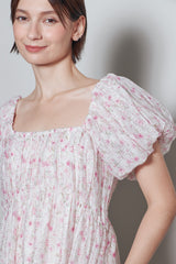 woman wearing a floral puff sleeve dress with a square neckline and gathered bodice