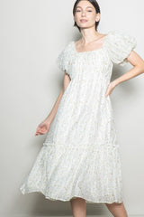 woman wearing a white floral midi dress with puff sleeves and a tiered skirt