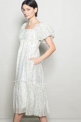 woman wearing a floral print midi dress with puff sleeves and pockets